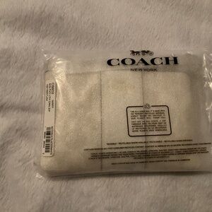 Coach corner white zip wristlet in signature canvas. This color will stand out.